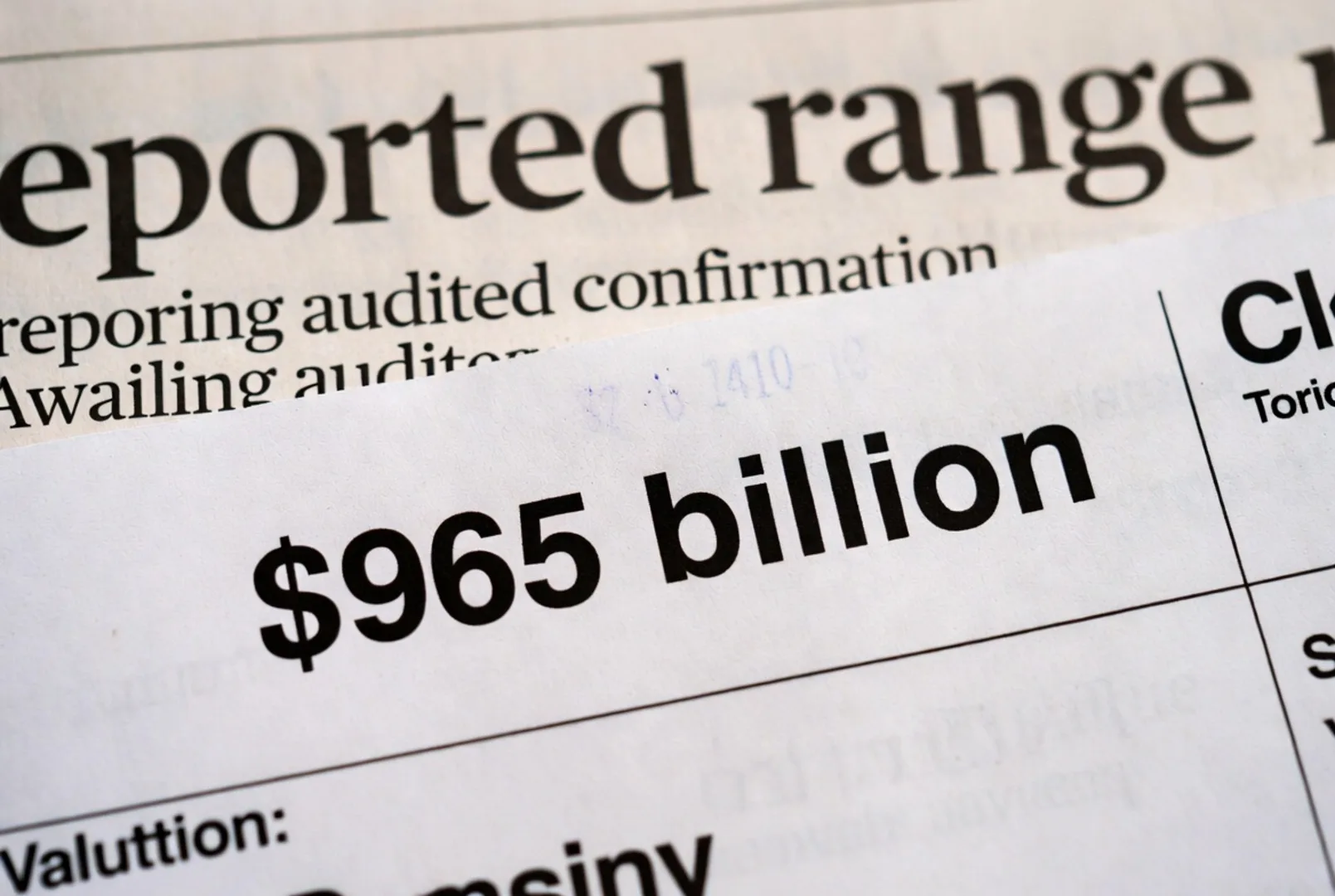 Printed clipping showing a $965 billion valuation figure beneath a reported range heading that notes the revenue number is awaiting audited confirmation